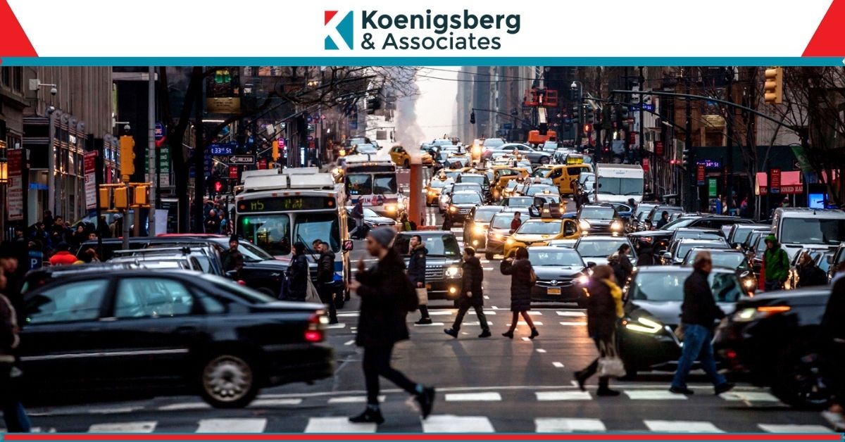 Busy new york street, including cars, busses, and pedestrians crossing