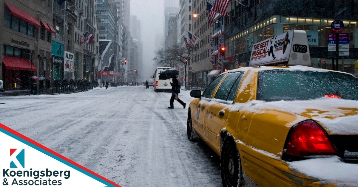 Pedestrian crosses snowy new york street