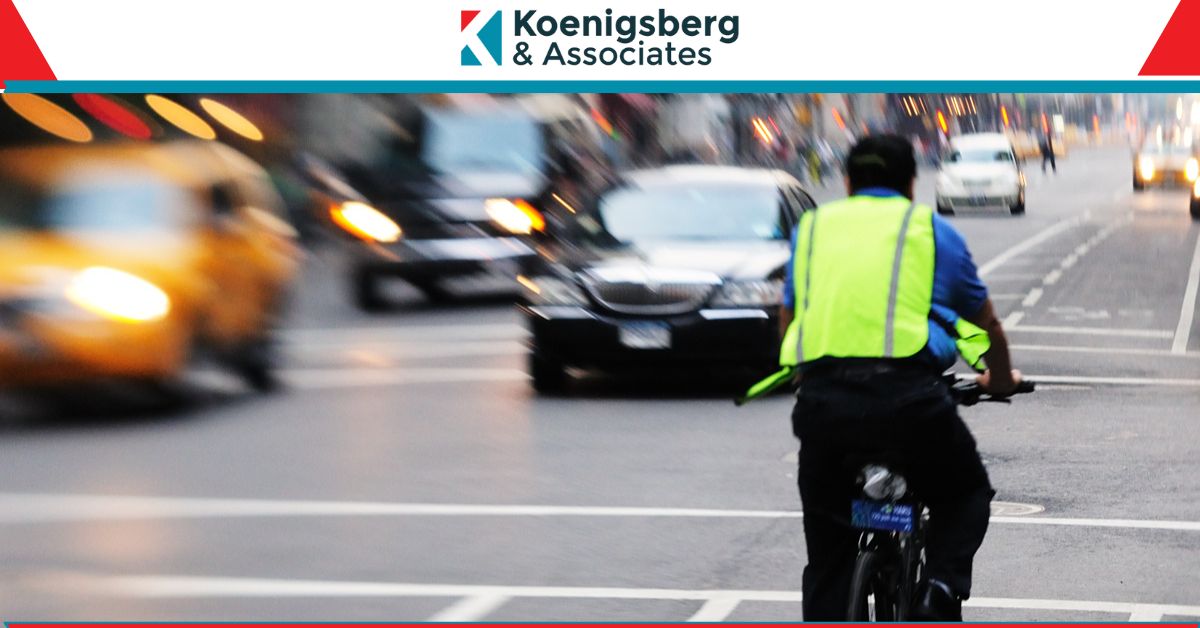 Cyclist riding along busy new york road