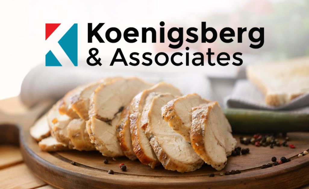 Sliced seasoned chicken breast on platter next to bread