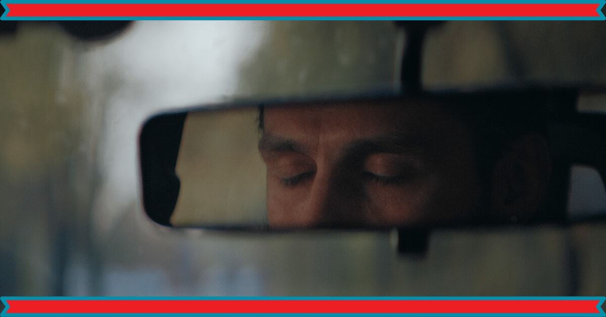 Man with eyes closed behind wheel