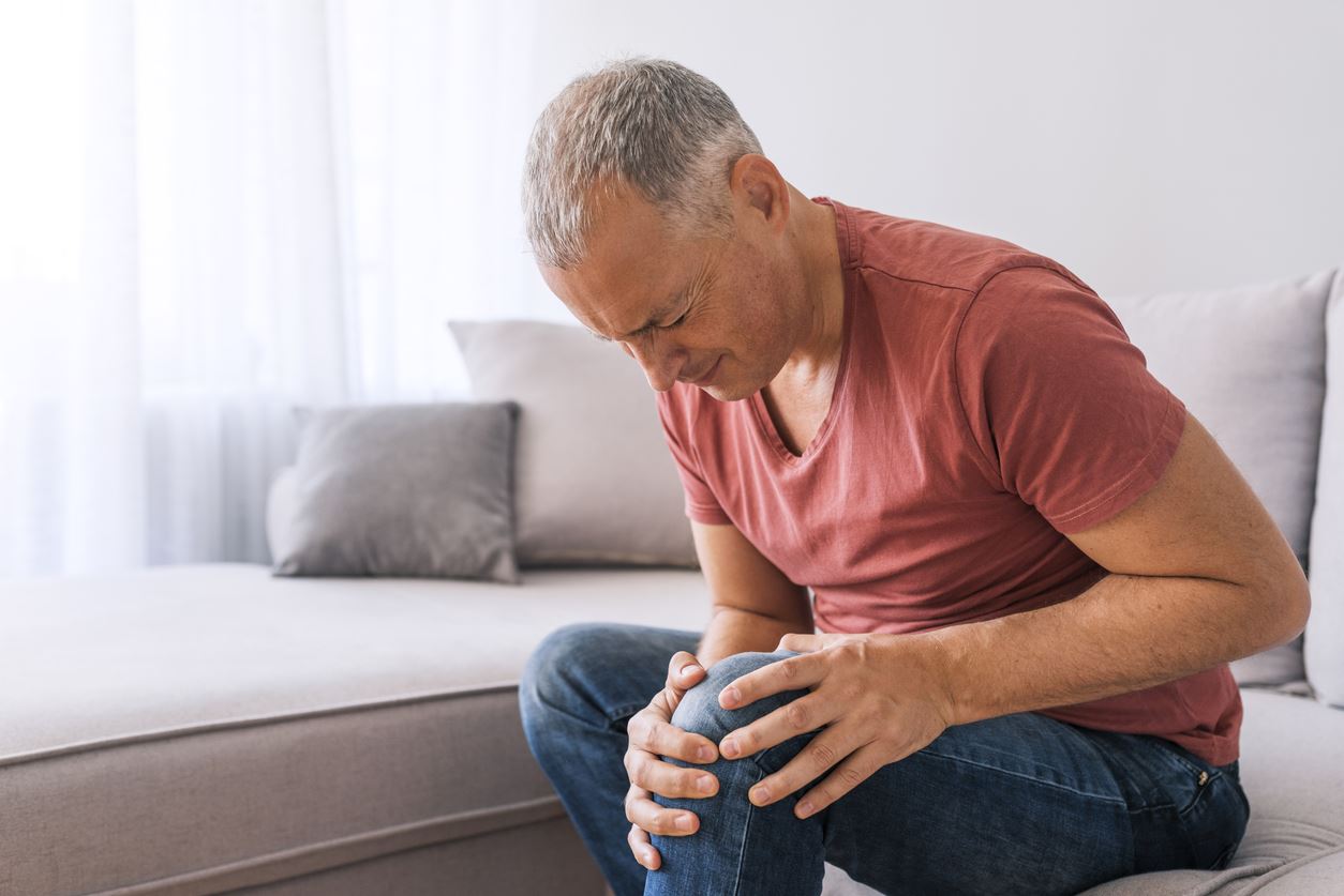 Man clutching knee in pain