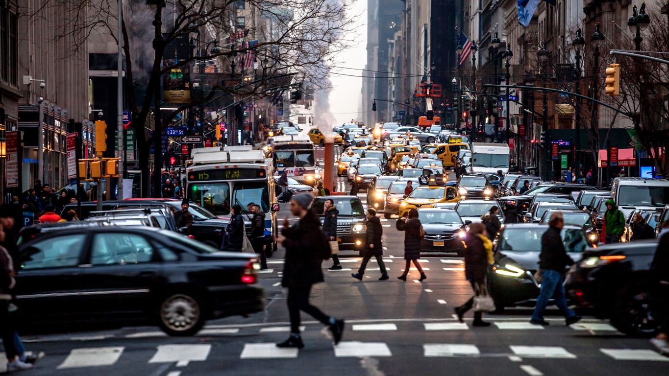 Busy new york street, including cars, busses, and pedestrians crossing