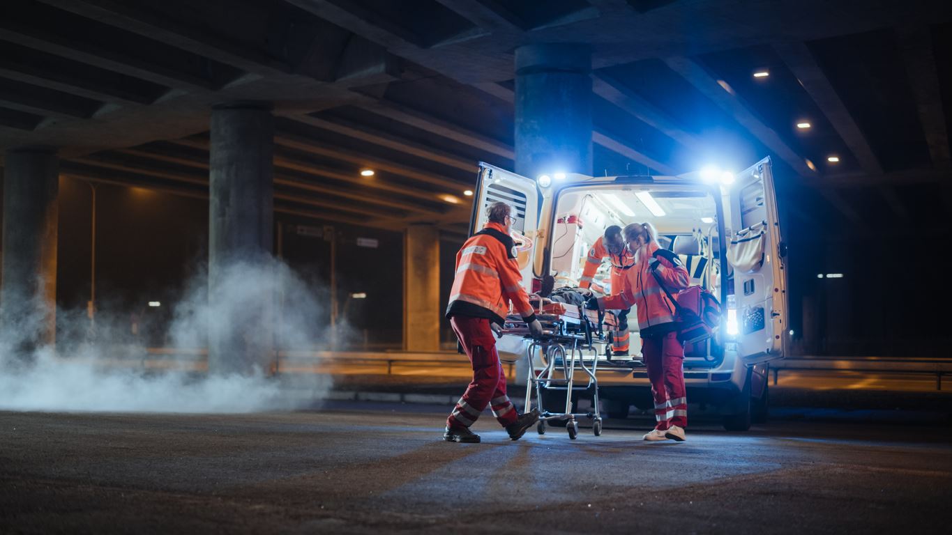 Paramedics lifting an injured person into truck