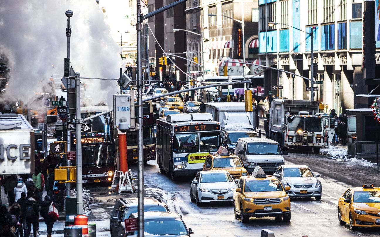 Busy new york street, including cars, busses, and pedestrians crossing