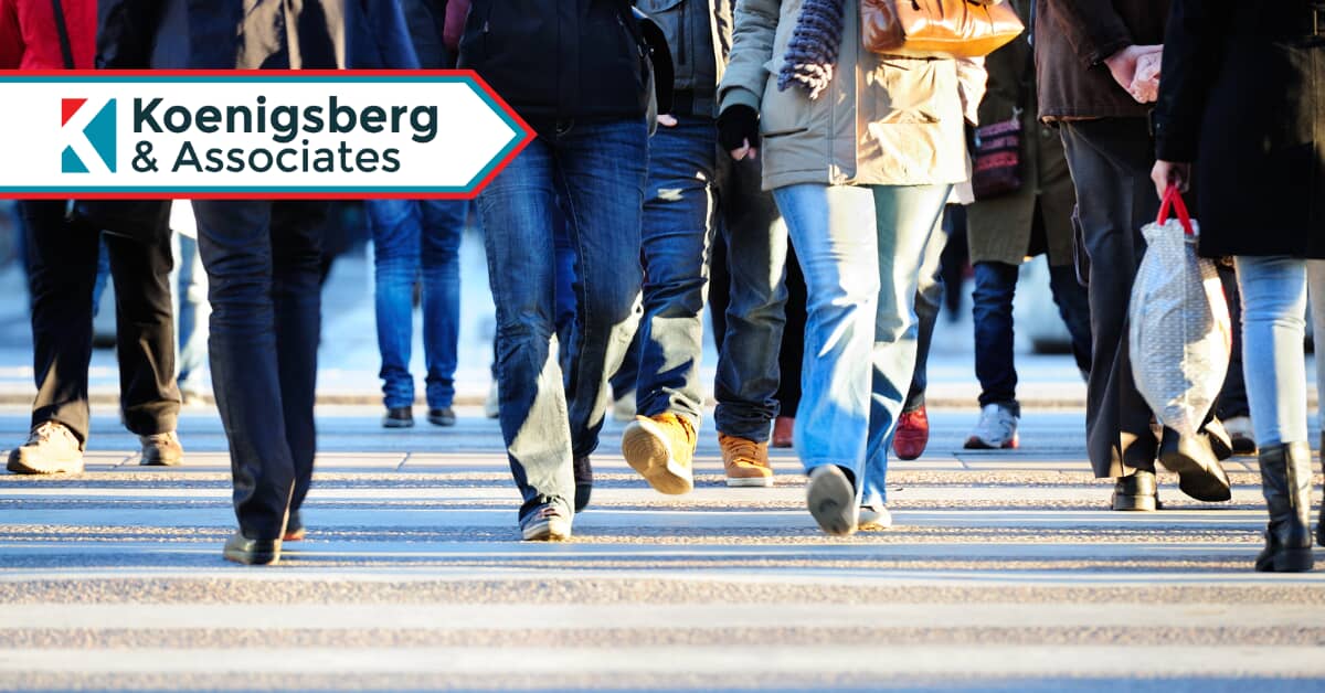 Crowds of people walking across a busy crosswalk at an intersection