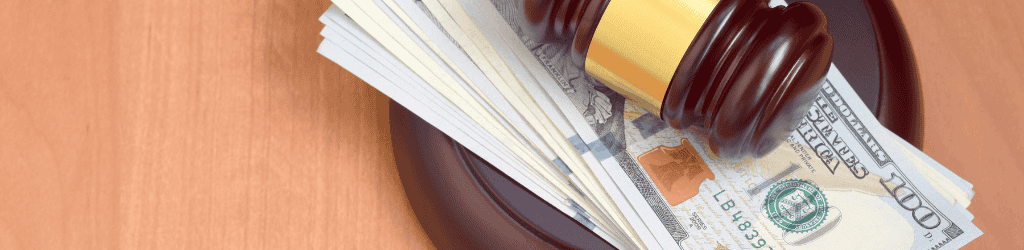 Gavel and Block with US Dollar Bills in Between